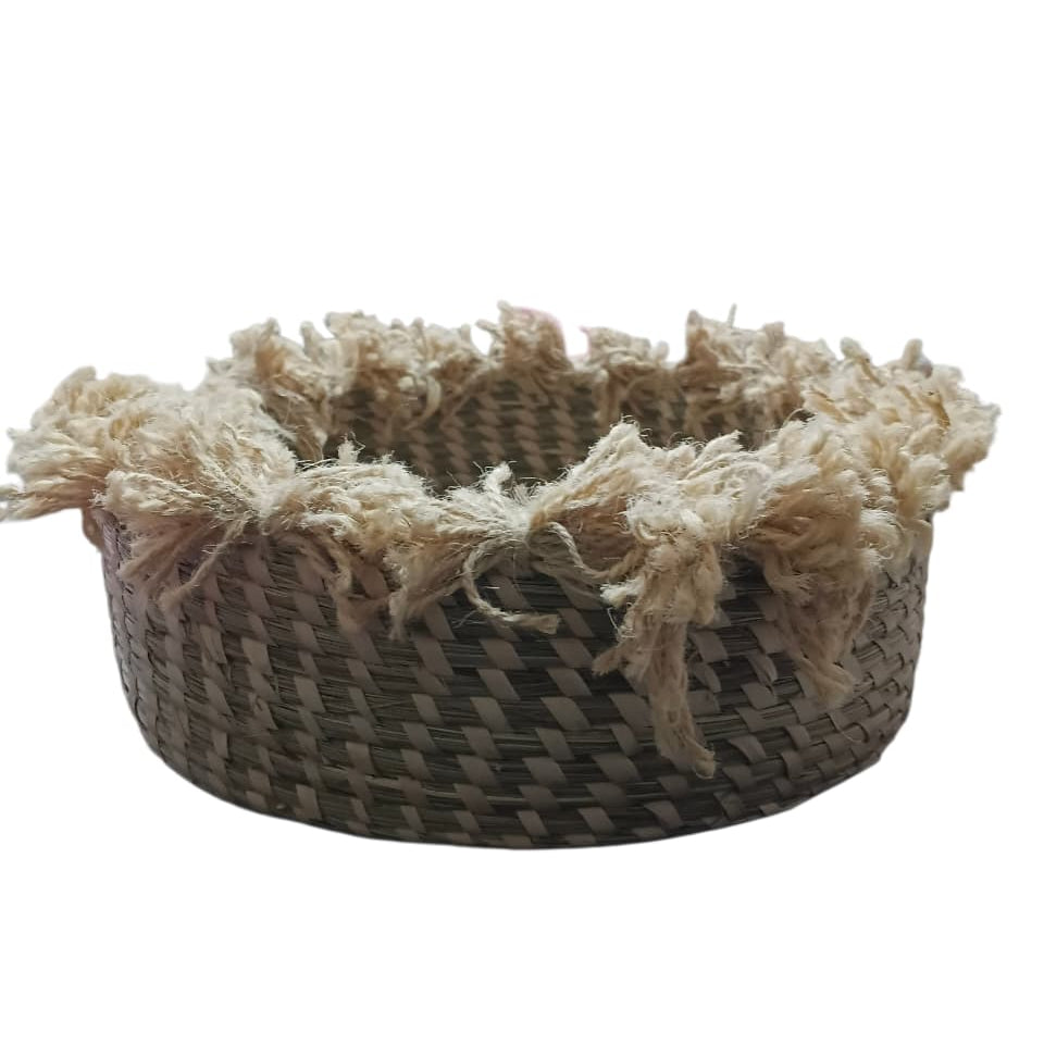 Woven basket with tassels on a white background